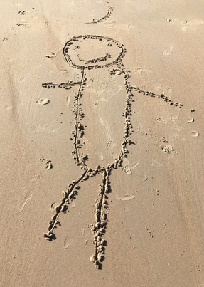 Stick figure drawn in the sand