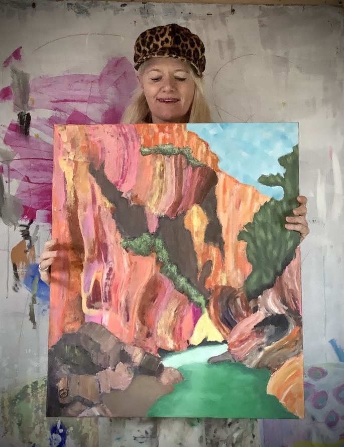 Painter holding her painting of a canyon